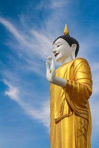 Low angle view of buddha statue against sky