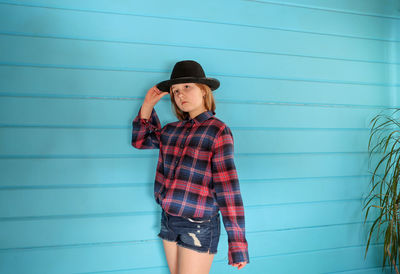 Portrait of a girl in a hat on a blue wooden background