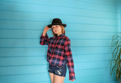 Young woman looking away against wall