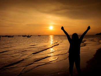 Silhouette man on beach against sky during sunset