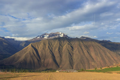 Scenic view of field and mountains against sky