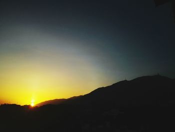 Scenic view of silhouette mountains against sky at sunset