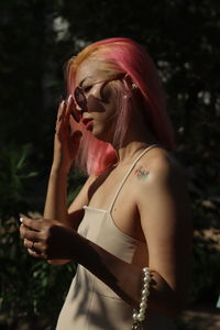 Low angle view of young woman with arms raised