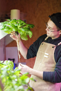 Chef checking vegetable plant roots in restaurant herb garden