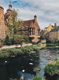 River by buildings against sky