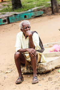 Senior man sitting on concrete