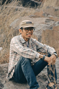 Portrait of young man sitting on land