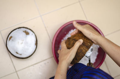 High angle view of woman holding ice cream on floor