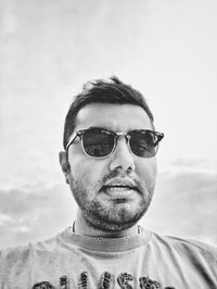 Portrait of young man wearing sunglasses against sky