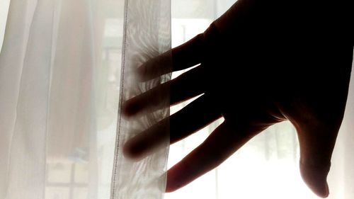 Close-up of woman hand in curtain