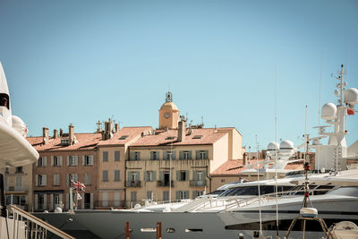 Boats in city against clear sky