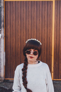 Woman standing against wooden door