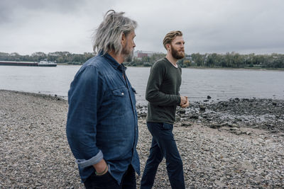 Father and son taking a stroll at rhine river, meeting to talk