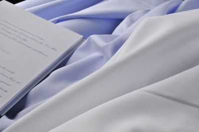 High angle view of white paper on bed