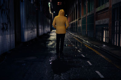Rear view of woman walking in tunnel