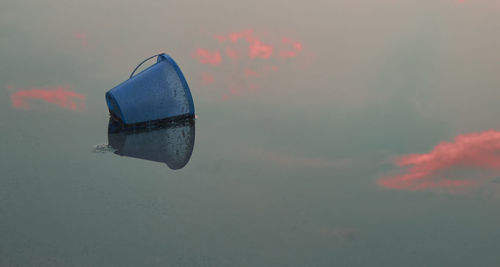 Close-up of reflection on lake against sky during sunset