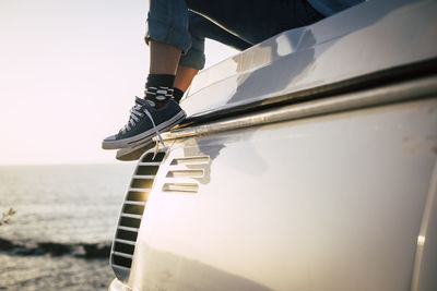 Low section of man on boat against sky