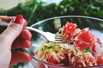 Cropped image of woman holding fork and bowl of food