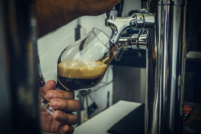 Close-up of man pouring coffee in glass