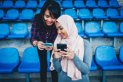 Full length of young woman using mobile phone