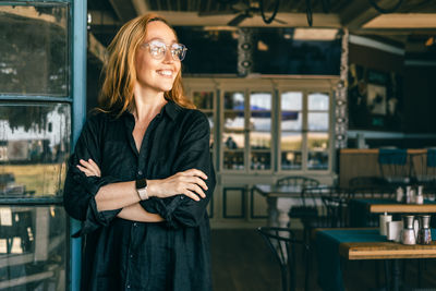 Portrait of young woman standing in cafe