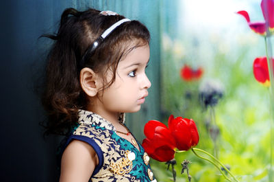 Close-up of girl with red flowers