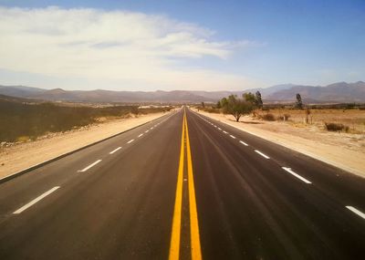 Empty road leading towards mountains