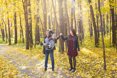 Full length of friends standing in forest