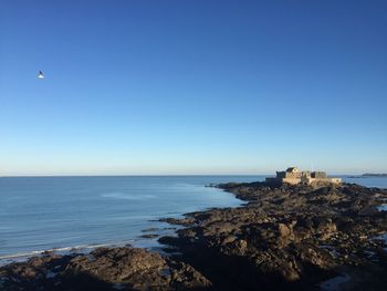 Scenic view of sea against clear blue sky