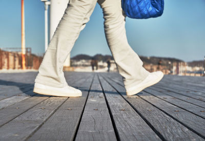Low section of woman walking on pier