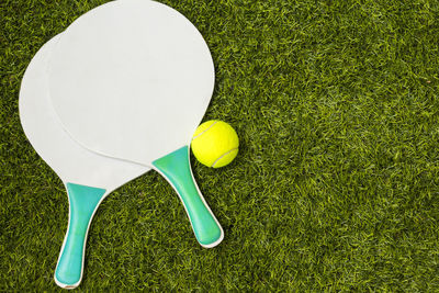 Table tennis rackets and ball on playing field