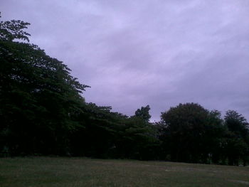 Scenic view of grassy field against cloudy sky