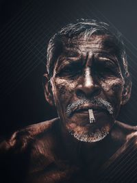 Close-up portrait of man wearing mask against black background