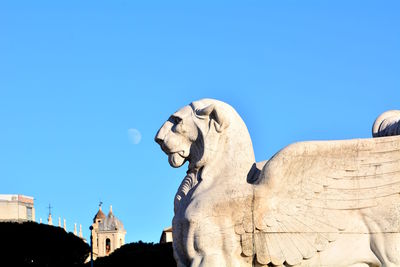 Low angle view of statue against blue sky