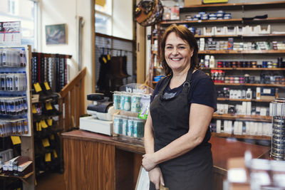 Portrait of happy shoemaker standing in shop