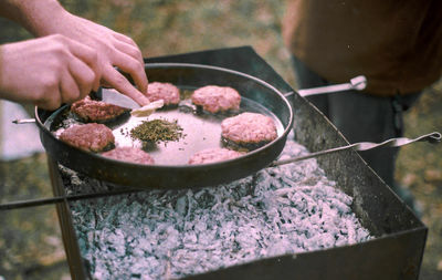 Close-up of hand grilling burgers