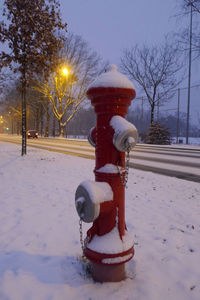 Fire hydrant on snow field against sky during winter