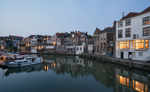 River by buildings against sky in city