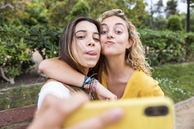 Friends taking selfie through smart phone in park