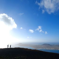 People standing on mountain against sky