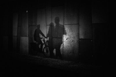 Shadow of people on wall at night