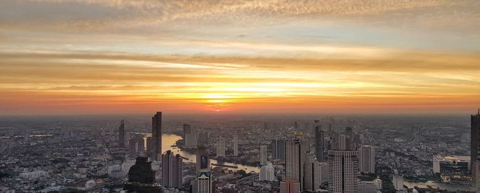 Aerial view of buildings in city during sunset