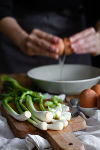 Midsection of person preparing food on cutting board