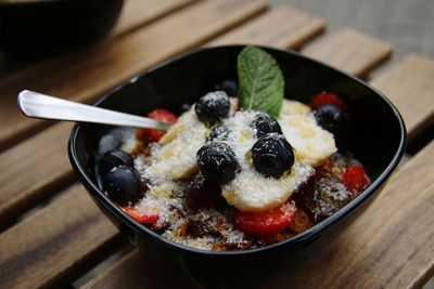 Close-up of fruit and cereal in breakfast bowl on table