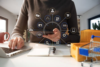 Midsection of man using laptop on table