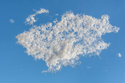 Low angle view of snow against blue sky