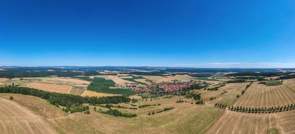 Aerial view of agricultural field against clear blue sky