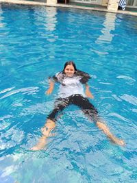 Portrait of a smiling young woman in swimming pool