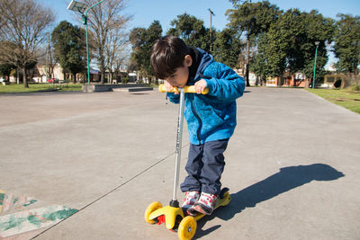 Little boy in skatepark with his scooter