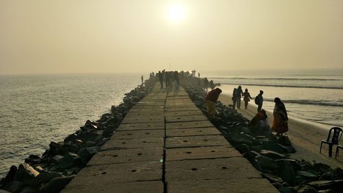 Pier over sea against sky during sunset